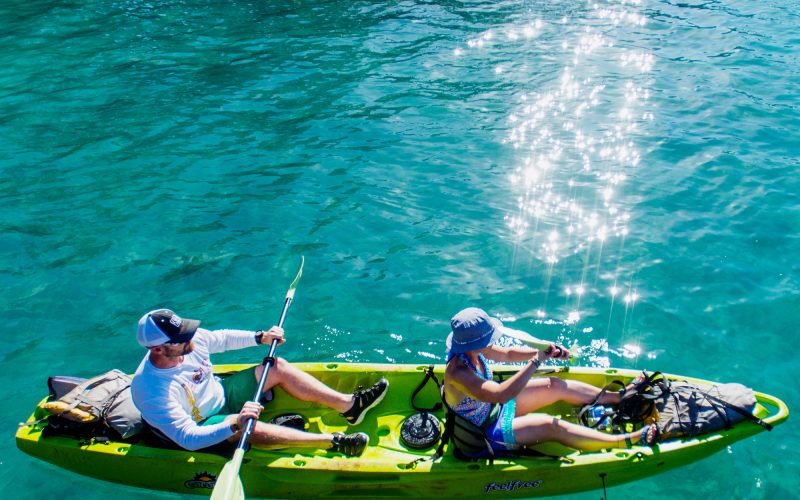Two people kayaking on clear turquoise water