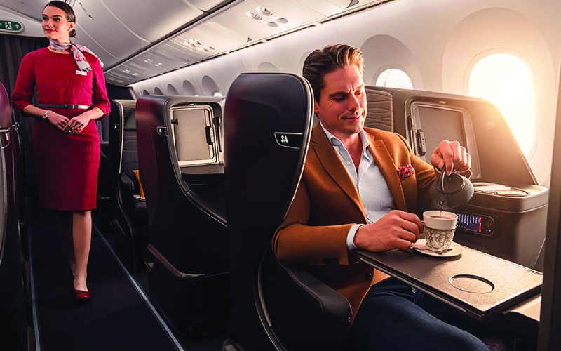 Man pouring tea in airline business class seat