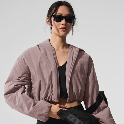 Woman wearing sunglasses and mauve cropped jacket